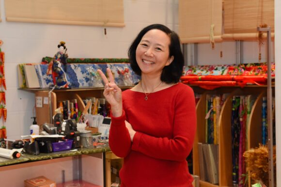 Woman in red sweater giving peace sign in store